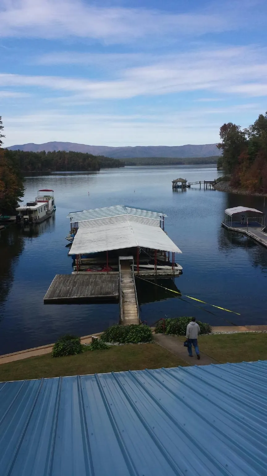View across a lake from a newly installed blue metal roof in Montgomery